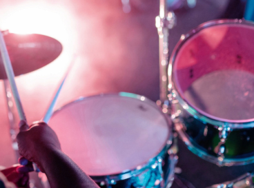 Batteur jouant sur une batterie sous des lumières de concert